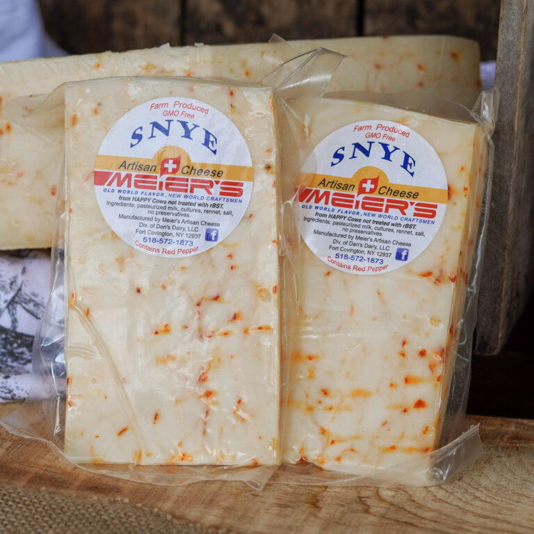 Artisan cheese labeled with ingredients and contact info