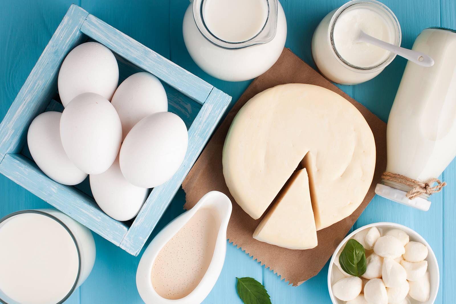 Milk, cheese, and eggs on wooden surface