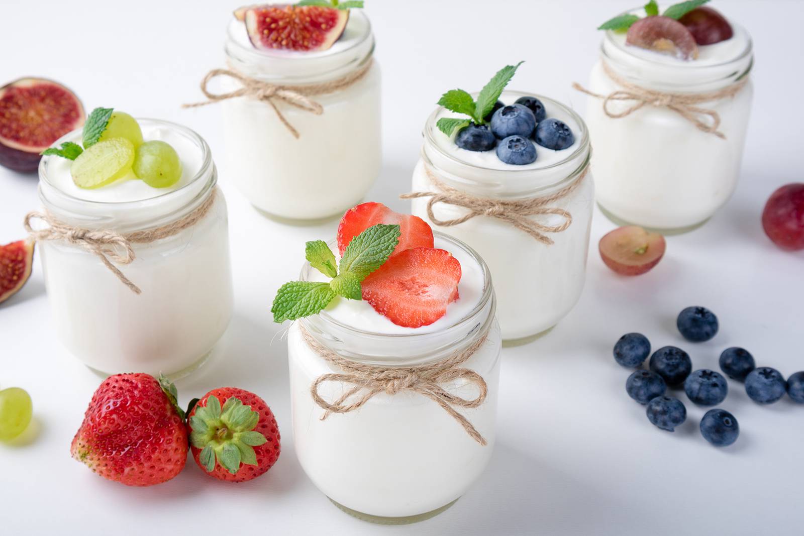 Assorted fruit-topped yogurt in jars