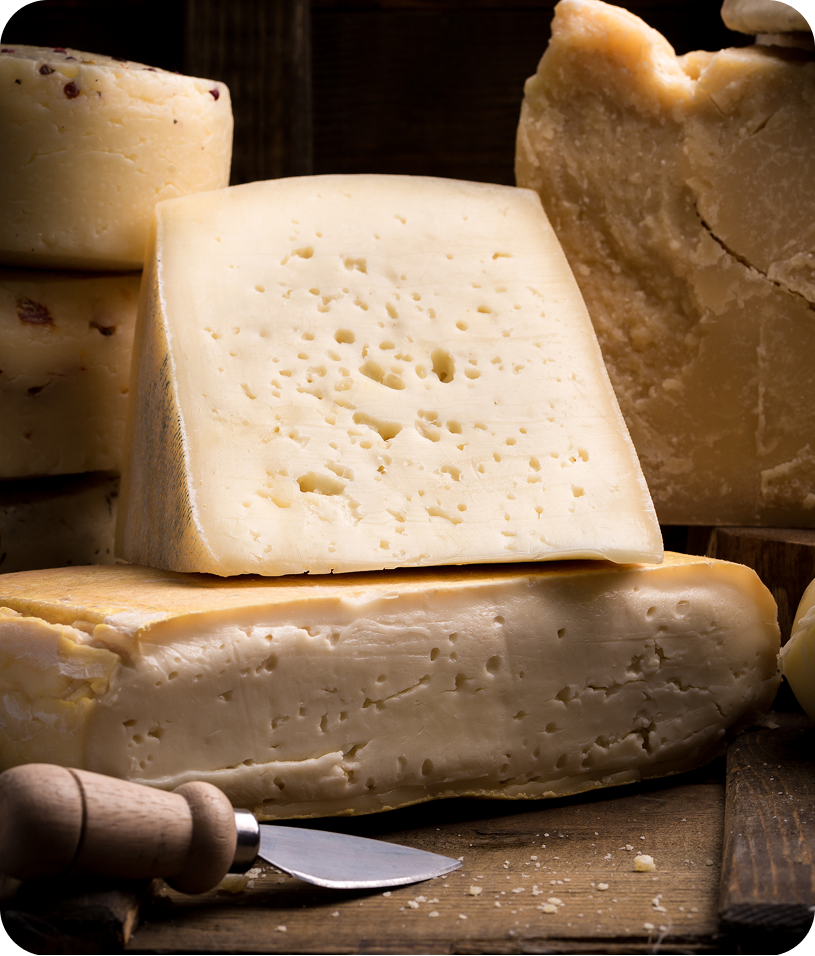 Assorted blocks of cheese with knife.