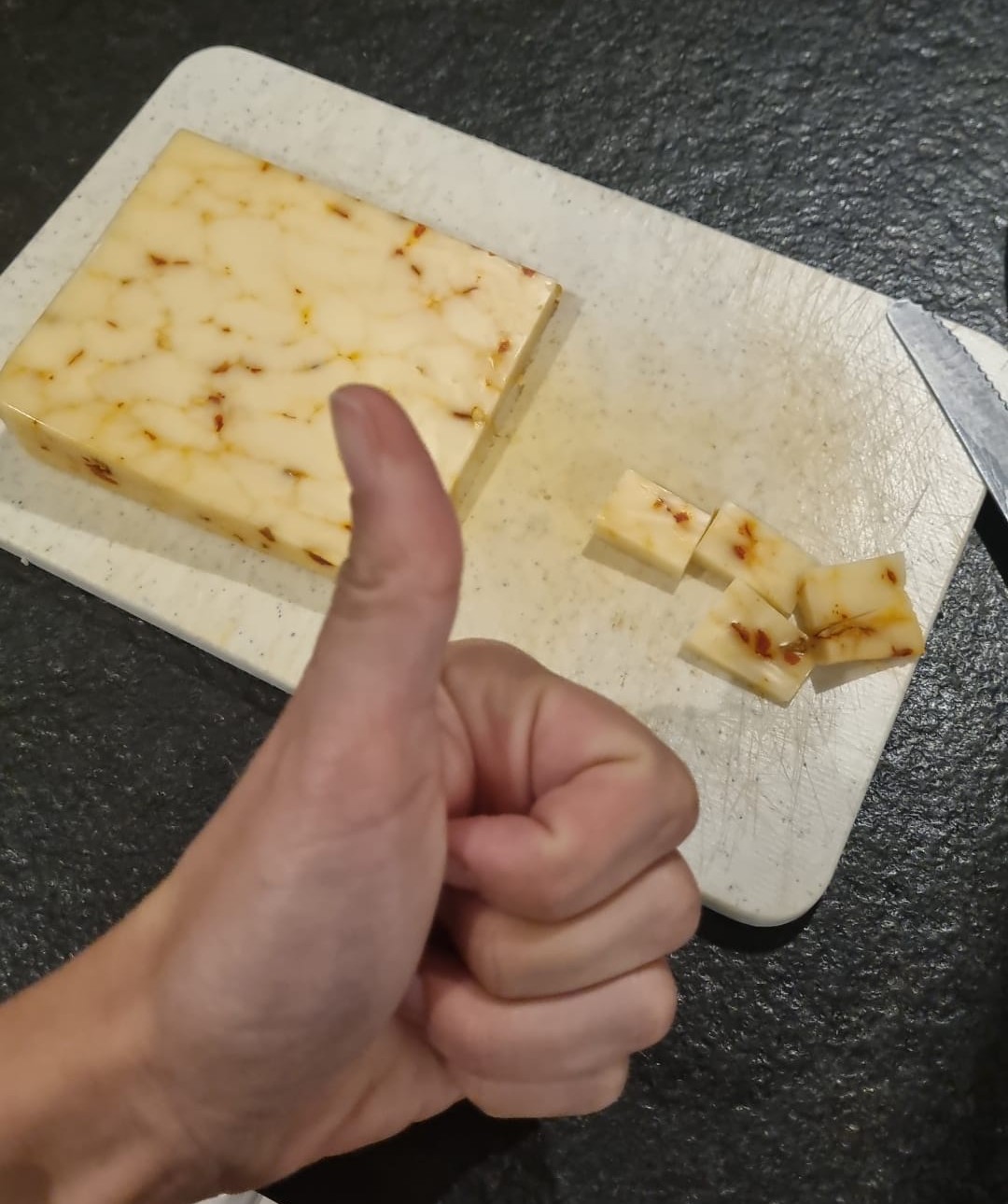 Thumbs-up beside cubed marbled cheese